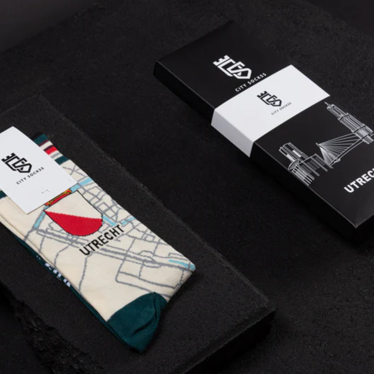 Sokken met het wapen van Utrecht en de kaart van de stad op de sok met doos erbij