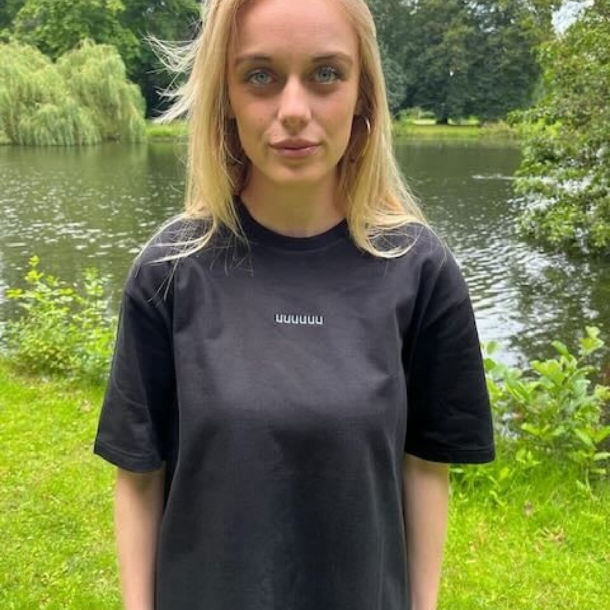 Zwart T-Shirt "UUUUUU" met lichtblauw gekleurde letters met model in het park