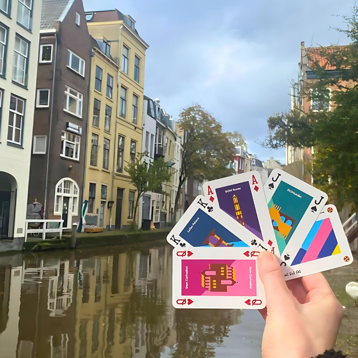 Hand met kaarten uitkijkend over de gracht