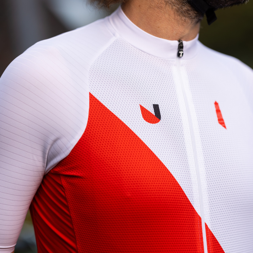 Wit Wielrenshirt met rode diagonaal. Er staat een kleine domtoren op de borst