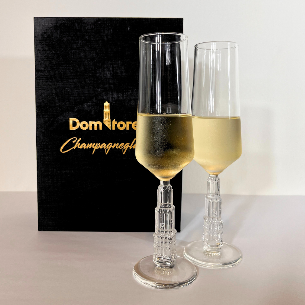 Met de hand geblazen champagneglazen met de Domtoren als voet. Met de doos op de achtergrond